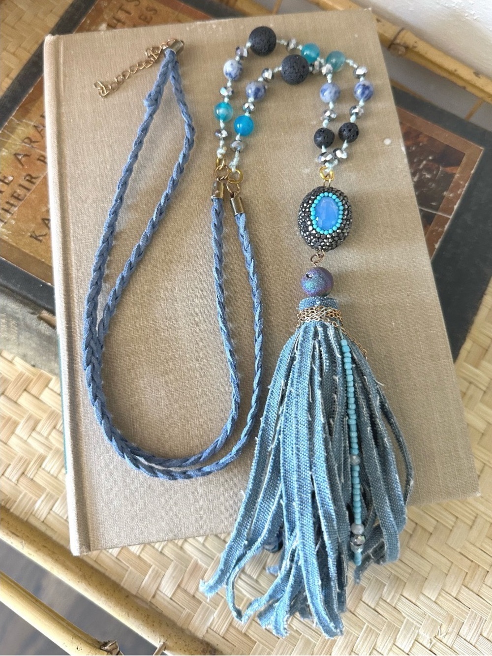 Beaded necklace featuring blue denim-style fringe tassel and stone accents